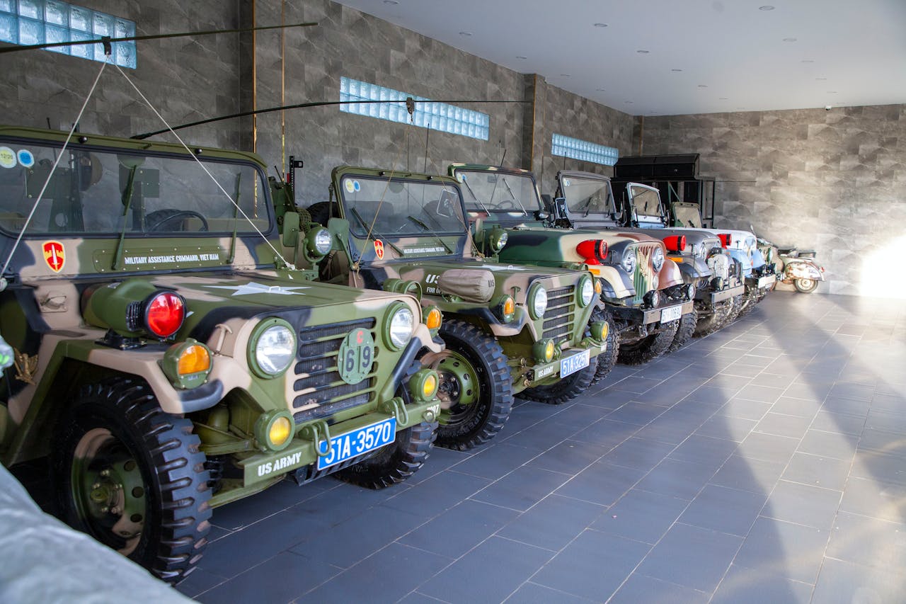 A collection of vintage military jeeps on display indoors, showcasing US Army vehicles.